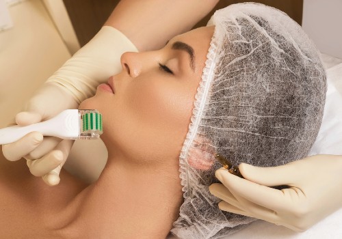 Practitioner using a small green derma roller on a reclining woman's chin