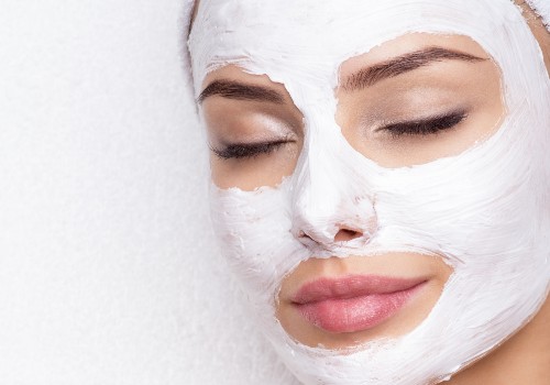 Close-up of a woman resting with her eyes closed and a white facial mask on her skin
