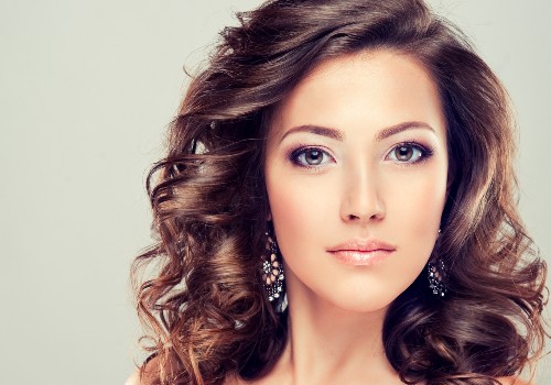 Portrait of a woman with curled hair, purple eye shadow, and dangling earrings