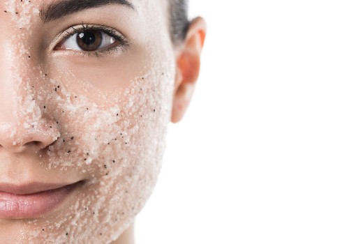 Close-up of a woman's cheek and nose covered with a grainy facial scrub