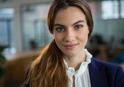 Portrait of a woman with her hair in a ponytail wearing a navy jacket and white blouse