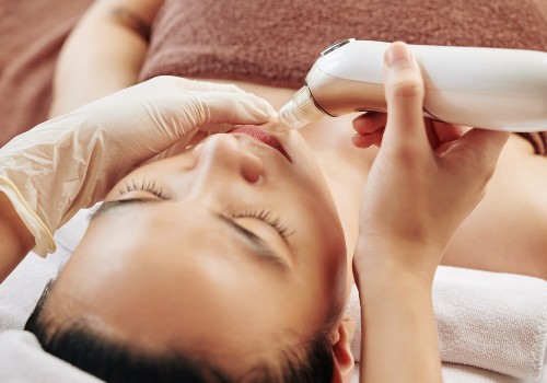 A cosmetologist using a pore vacuum for cleaning