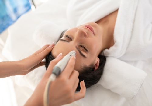 A cosmetologist using a pore vacuum in a spa