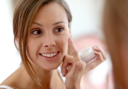 A girl moisturizing her face