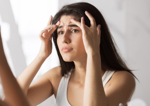 A woman trying to reduce forehead wrinkles