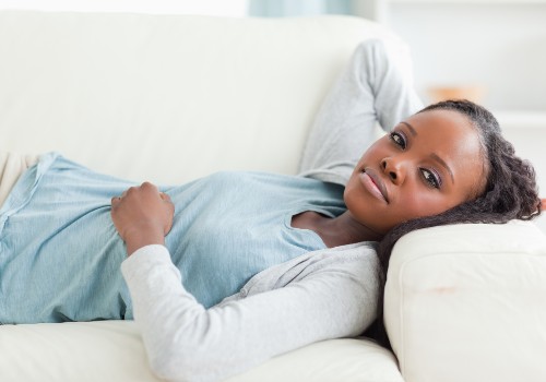 A woman with excellent skin is resting on a couch